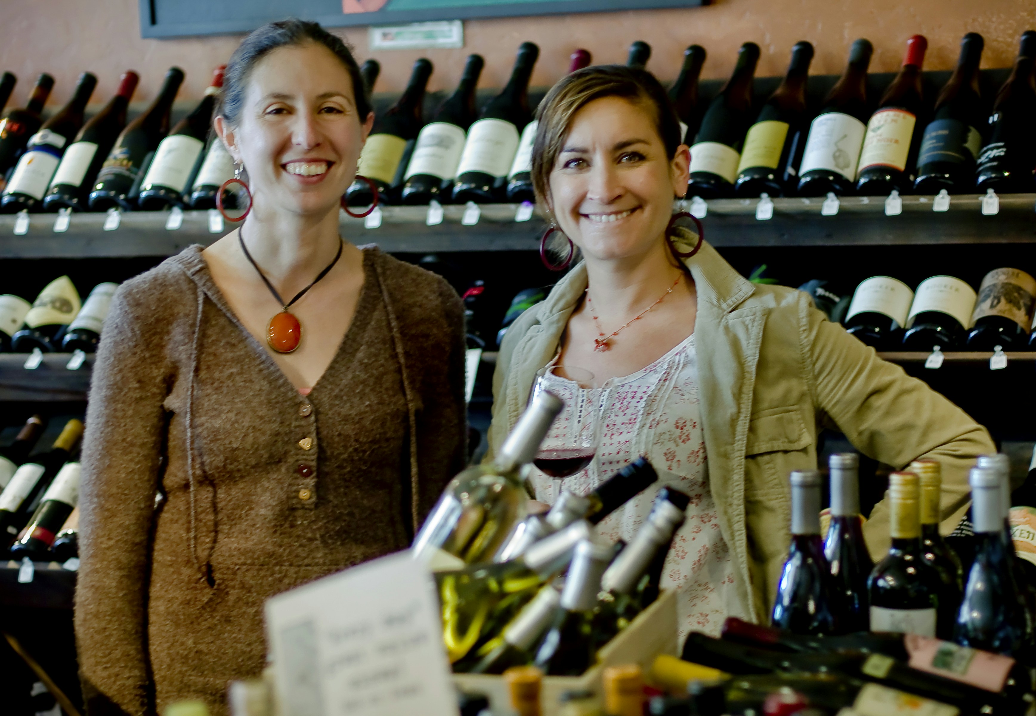 woman in brown jacket standing beside woman in white shirt