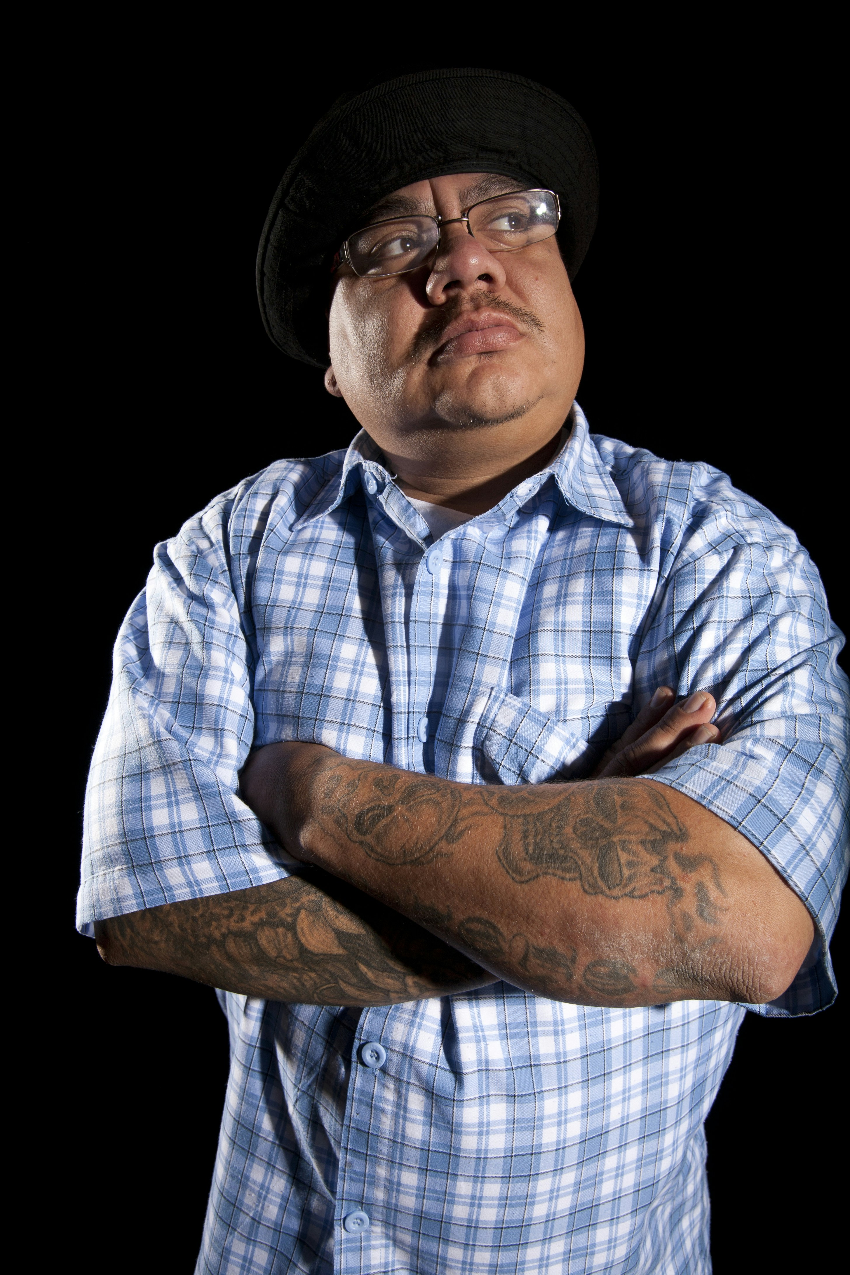 man in blue white and gray plaid button up shirt wearing black hat