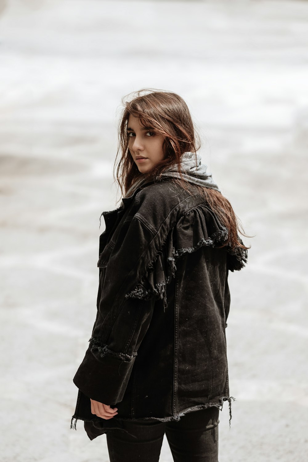 woman in black jacket standing on snow covered ground during daytime