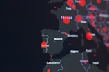 A dark-themed map highlighting parts of Europe and North Africa with red circles indicating specific locations. Major cities like Lisbon, Madrid, and Casablanca are labeled. The circles suggest a possible data visualization, such as population density or COVID-19 cases.