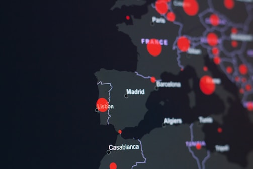 A dark-themed map highlighting parts of Europe and North Africa with red circles indicating specific locations. Major cities like Lisbon, Madrid, and Casablanca are labeled. The circles suggest a possible data visualization, such as population density or COVID-19 cases.