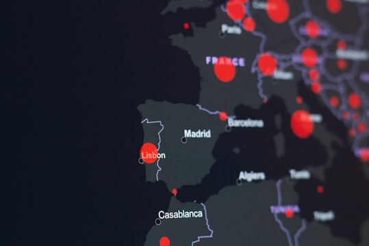 A dark-themed map highlighting parts of Europe and North Africa with red circles indicating specific locations. Major cities like Lisbon, Madrid, and Casablanca are labeled. The circles suggest a possible data visualization, such as population density or COVID-19 cases.