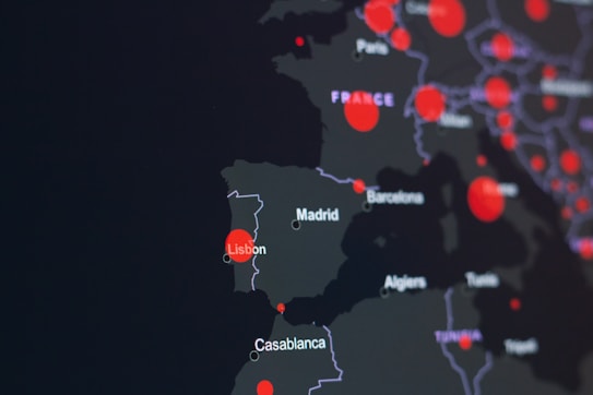 A dark-themed map highlighting parts of Europe and North Africa with red circles indicating specific locations. Major cities like Lisbon, Madrid, and Casablanca are labeled. The circles suggest a possible data visualization, such as population density or COVID-19 cases.