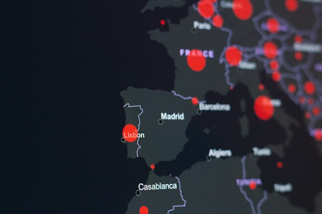 A dark-themed map highlighting parts of Europe and North Africa with red circles indicating specific locations. Major cities like Lisbon, Madrid, and Casablanca are labeled. The circles suggest a possible data visualization, such as population density or COVID-19 cases.