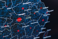 A digital map showcasing regions in China with a network of blue lines representing boundaries and red dots indicating key locations such as Wuhan, Xianfan, Hefei, and others. The background is dark, highlighting the contrast of the blue and red elements.