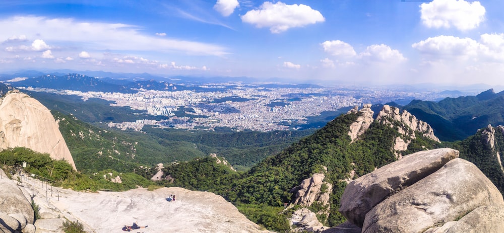 person sitting on rock mountain during daytime