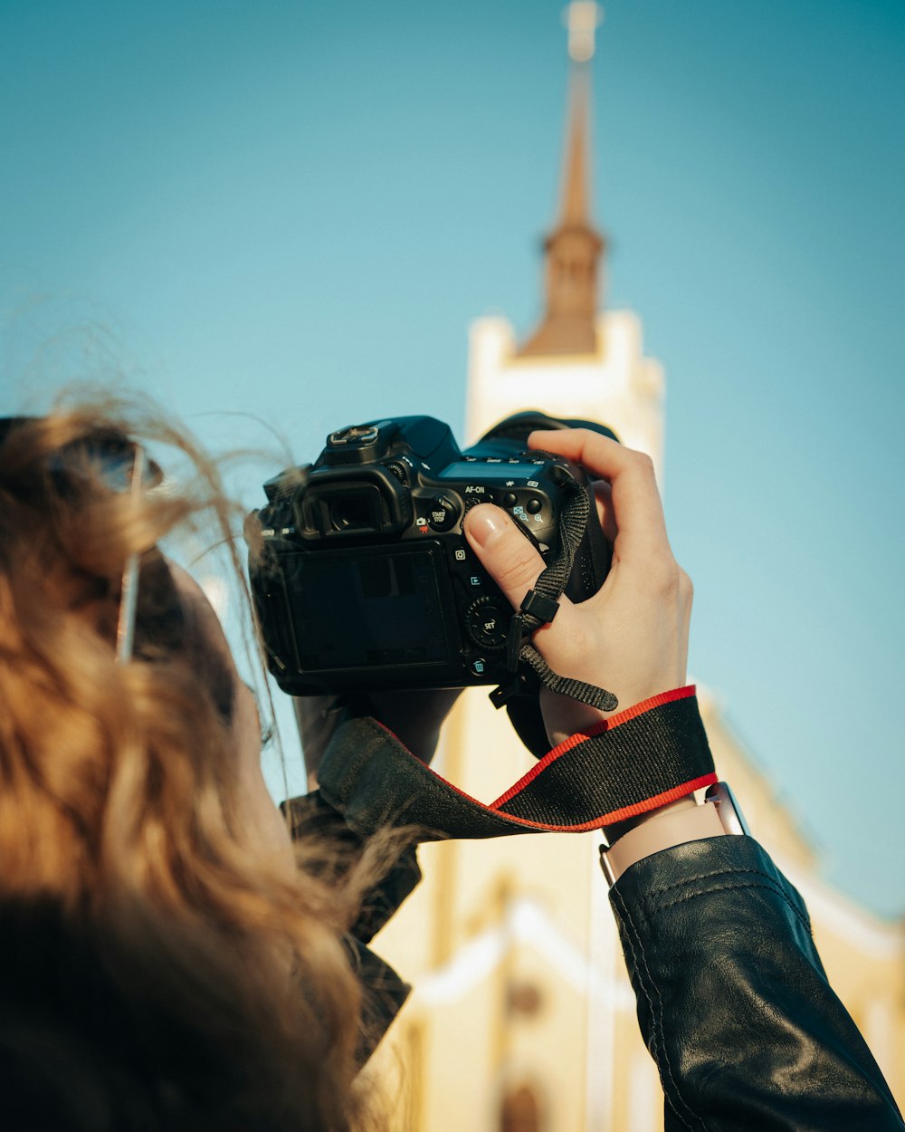 woman in black jacket holding black dslr camera