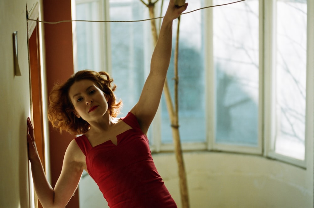 woman in red tank top holding on white rope