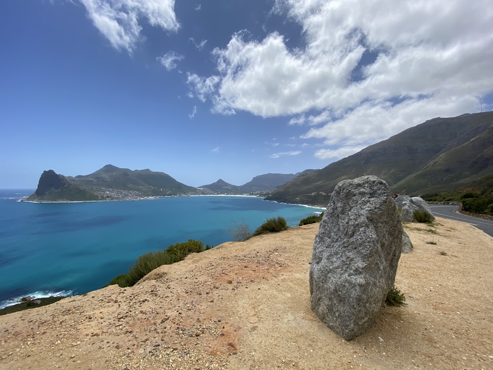 gray rock formation near body of water under blue sky during daytime