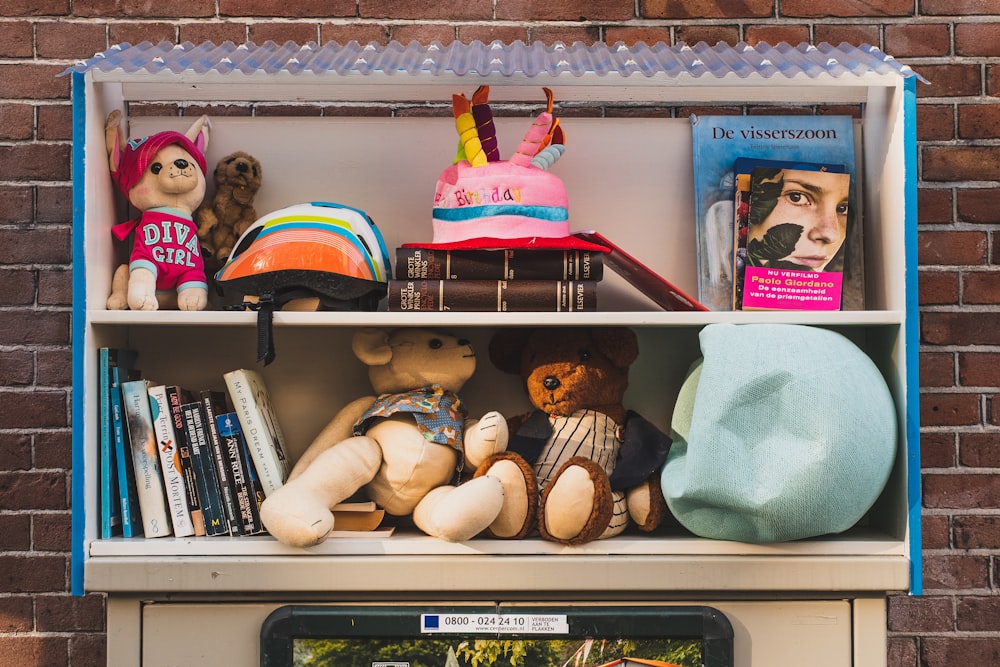 a book shelf filled with books and stuffed animals