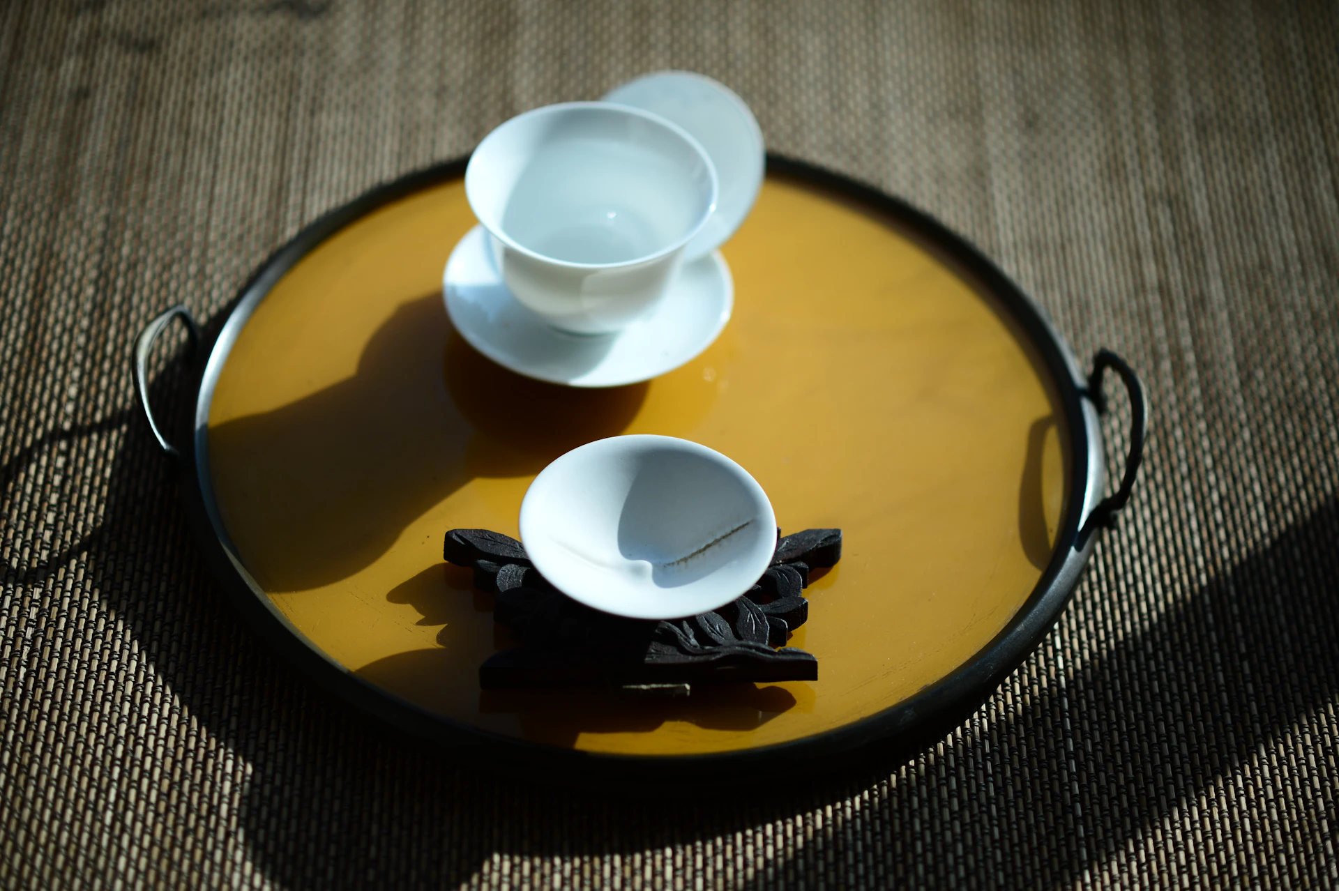 white ceramic teacup on brown ceramic plate