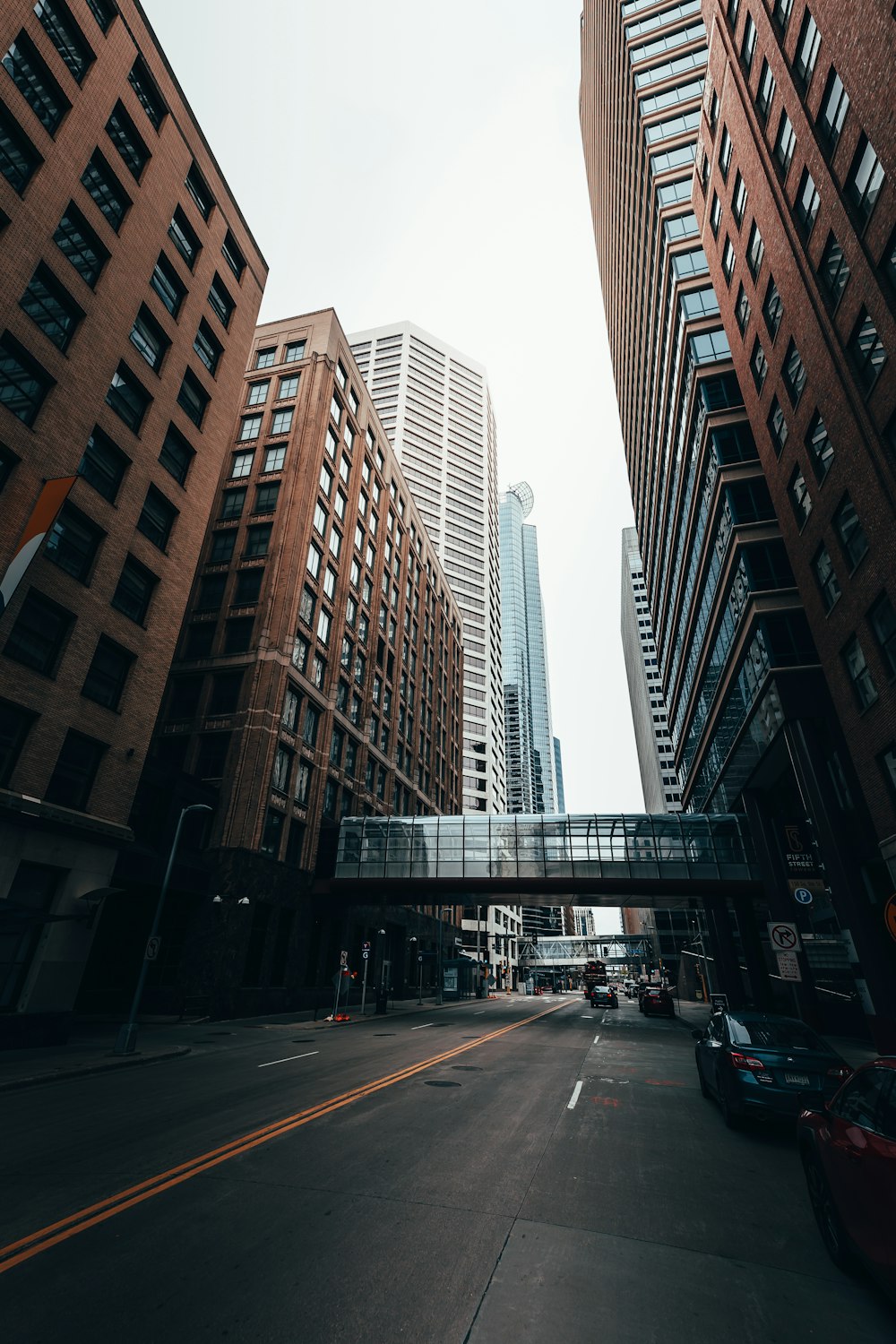 cars on road between high rise buildings during daytime