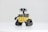 A small robot with large binocular-style eyes, tank-like treads, and a yellow cubical body, standing on a plain white surface. The robot has a distinctively cute and curious appearance.