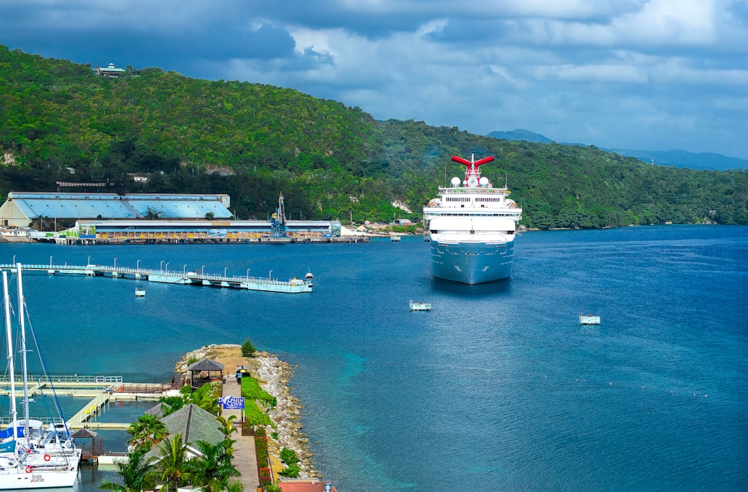 A cruise ship makes its way to the shore in Ochos Rios Jamaica on a cloudy day. 