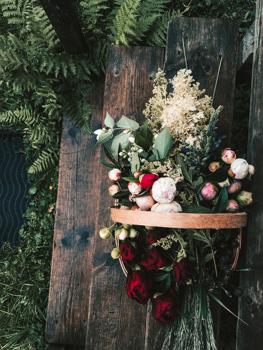 white and red flowers on brown wooden table