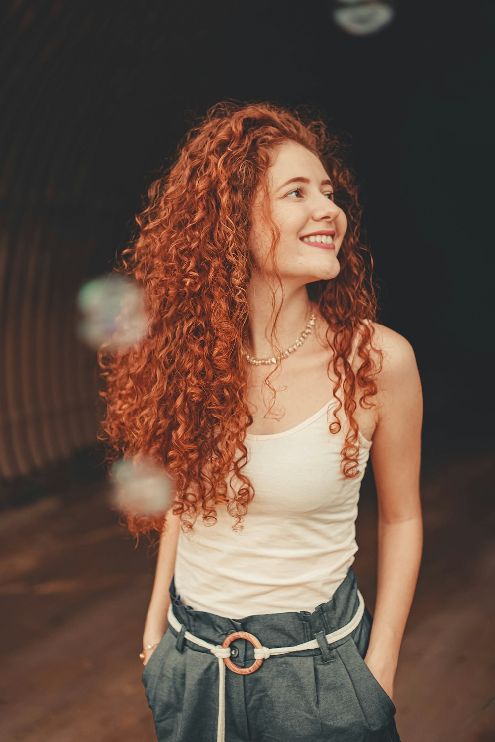 woman in white tank top smiling