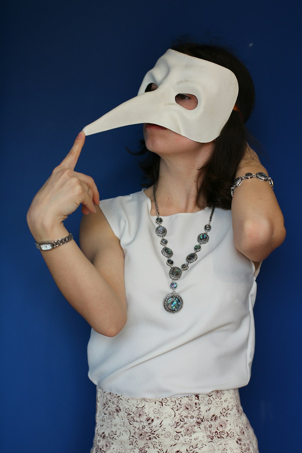 woman in white tank top covering her face with white mask