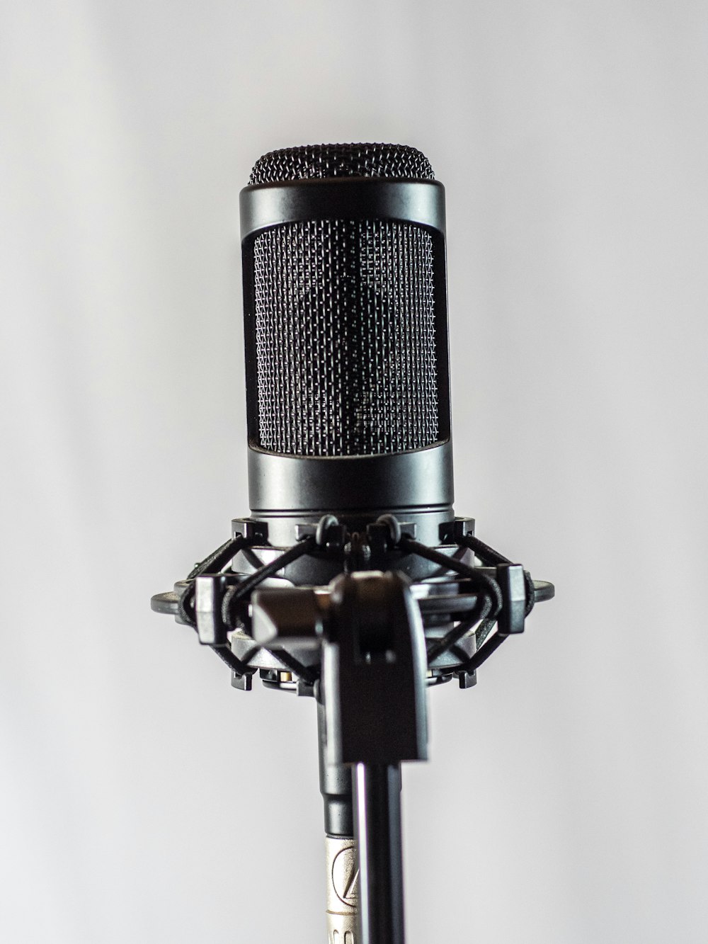black and silver microphone on white textile