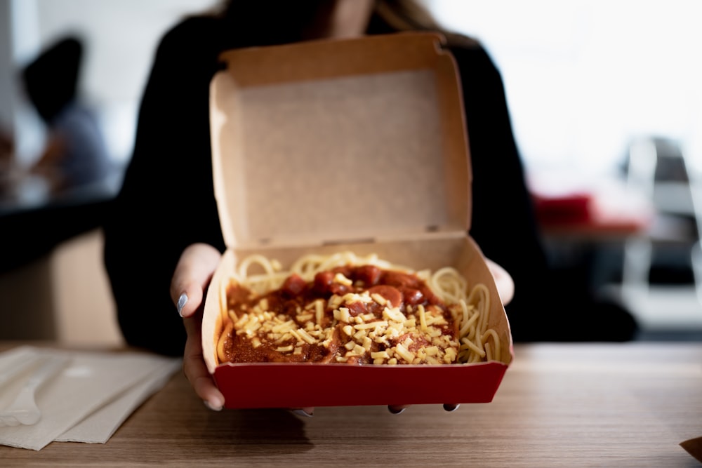 person holding brown cardboard box