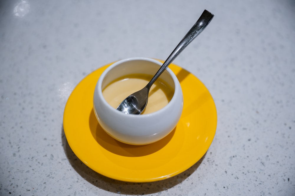 stainless steel spoon on yellow ceramic bowl