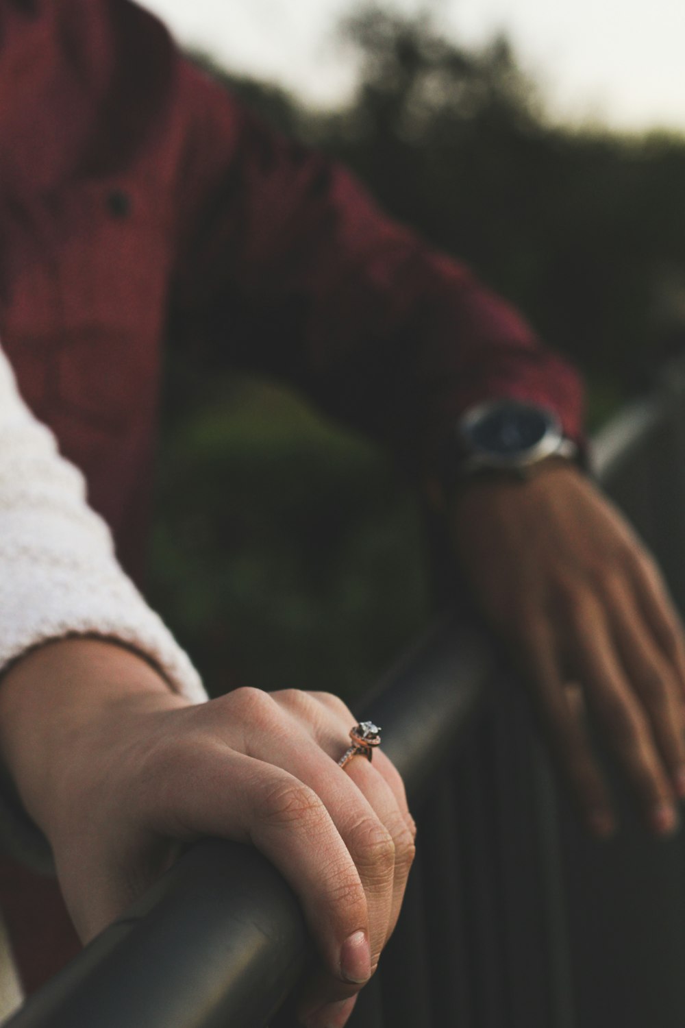 person in red long sleeve shirt wearing gold ring