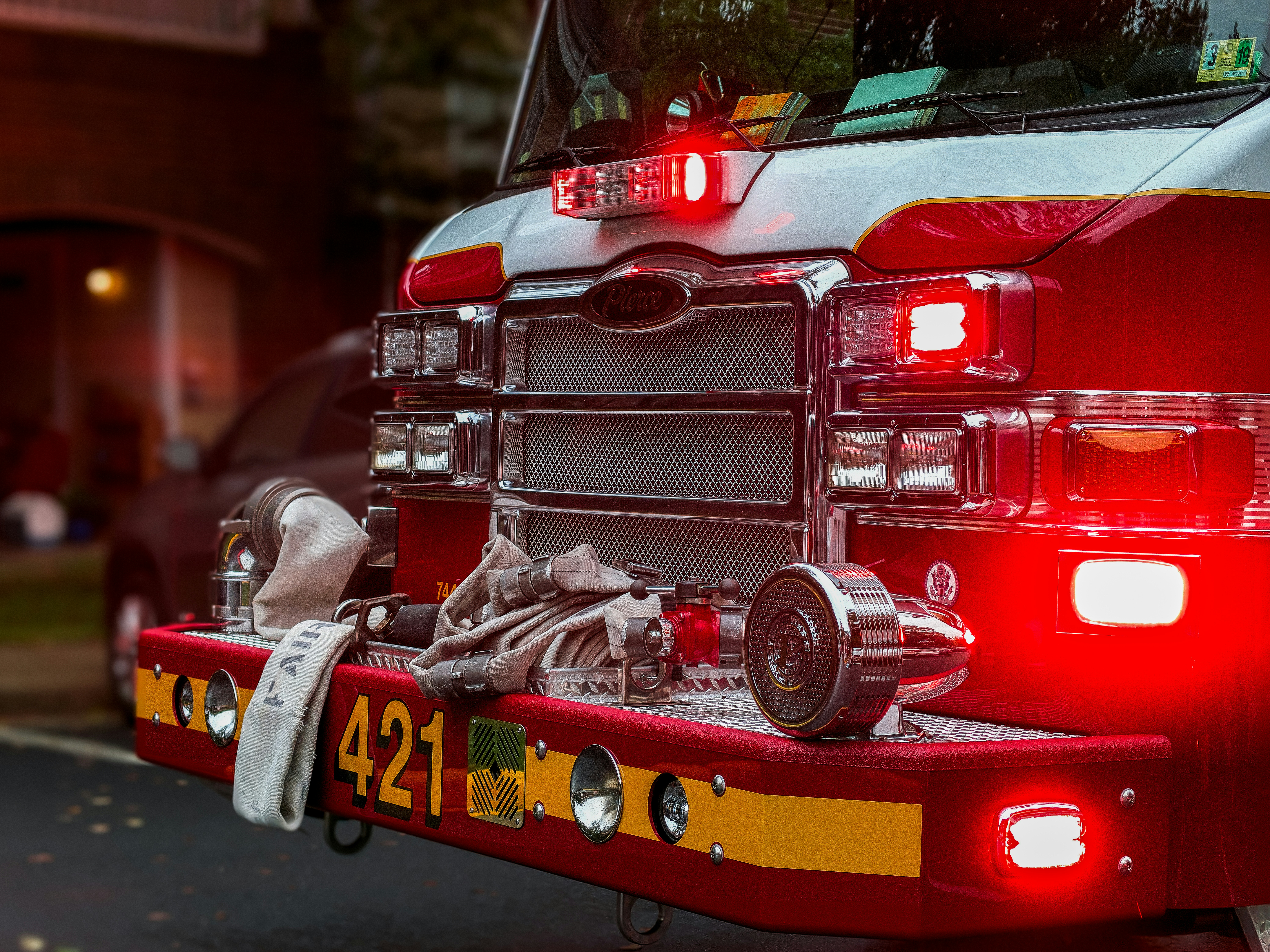 A fire truck carrying first responders and displaying emergency lights - parked outside of an apartment building in Fairfax Virginia.