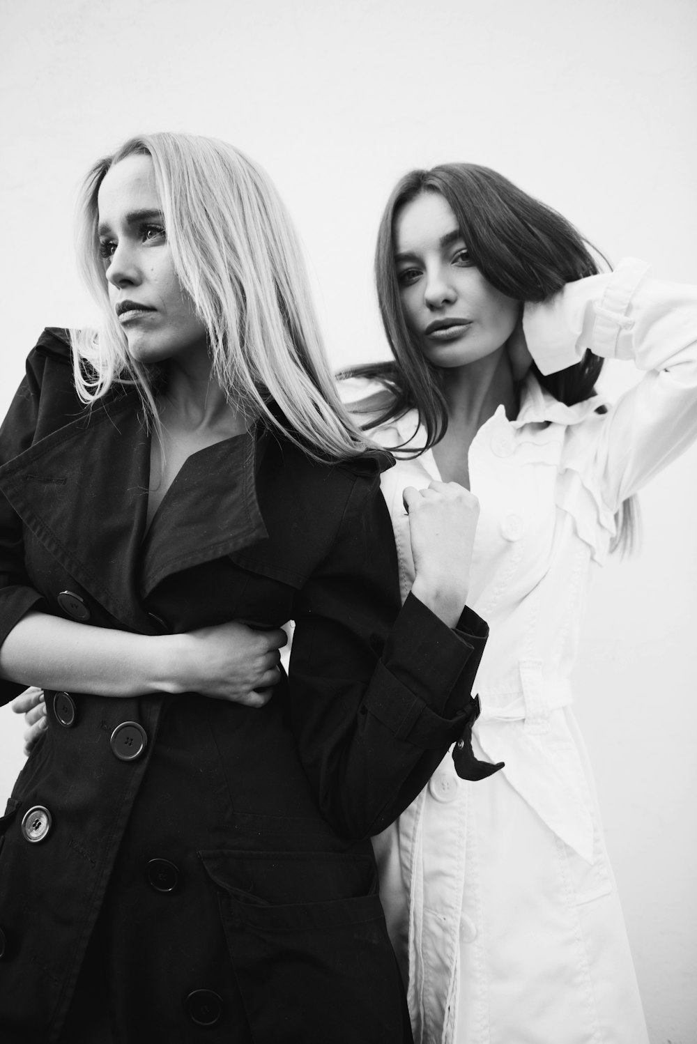 woman in black coat standing beside woman in white coat