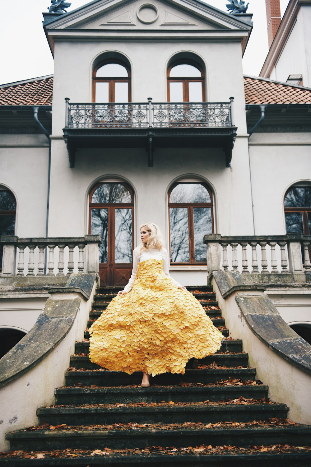 woman in yellow floral dress standing on stairs