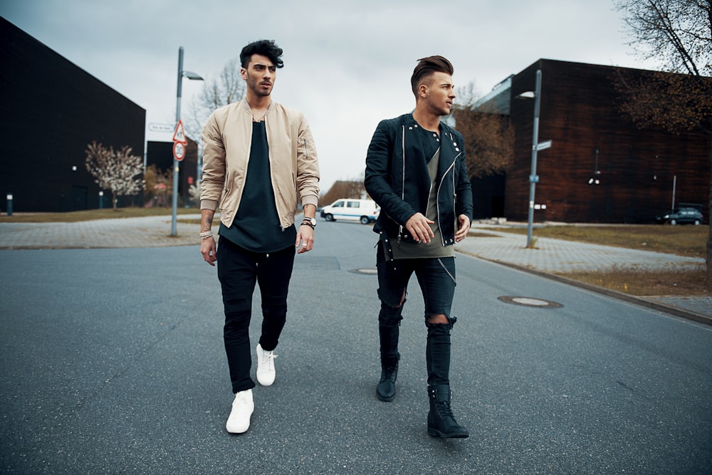 man in white crew neck shirt and black jacket walking on street during daytime