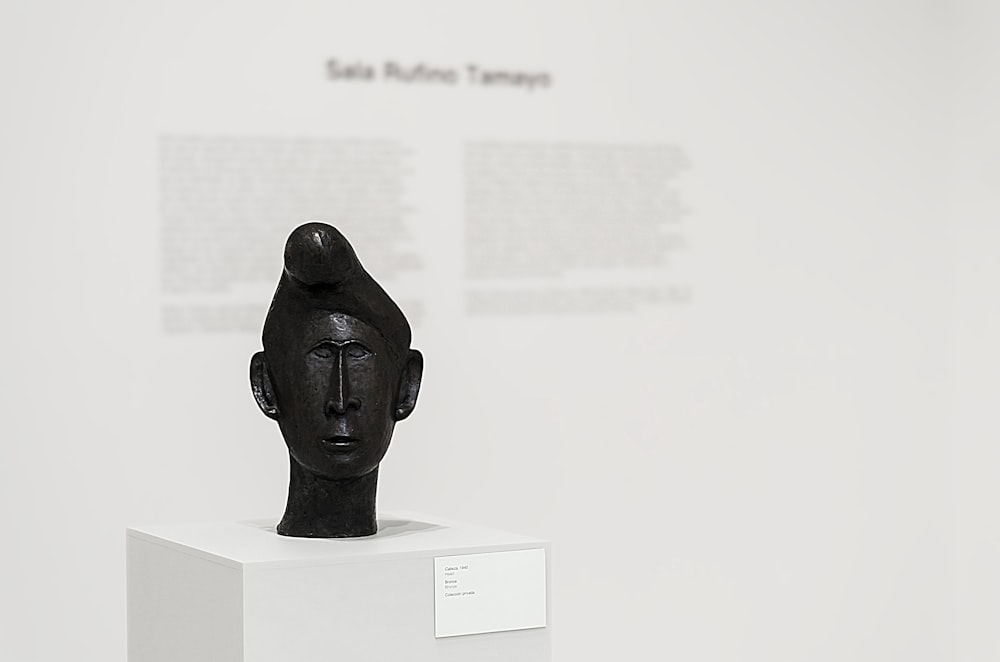 black human head bust on white table