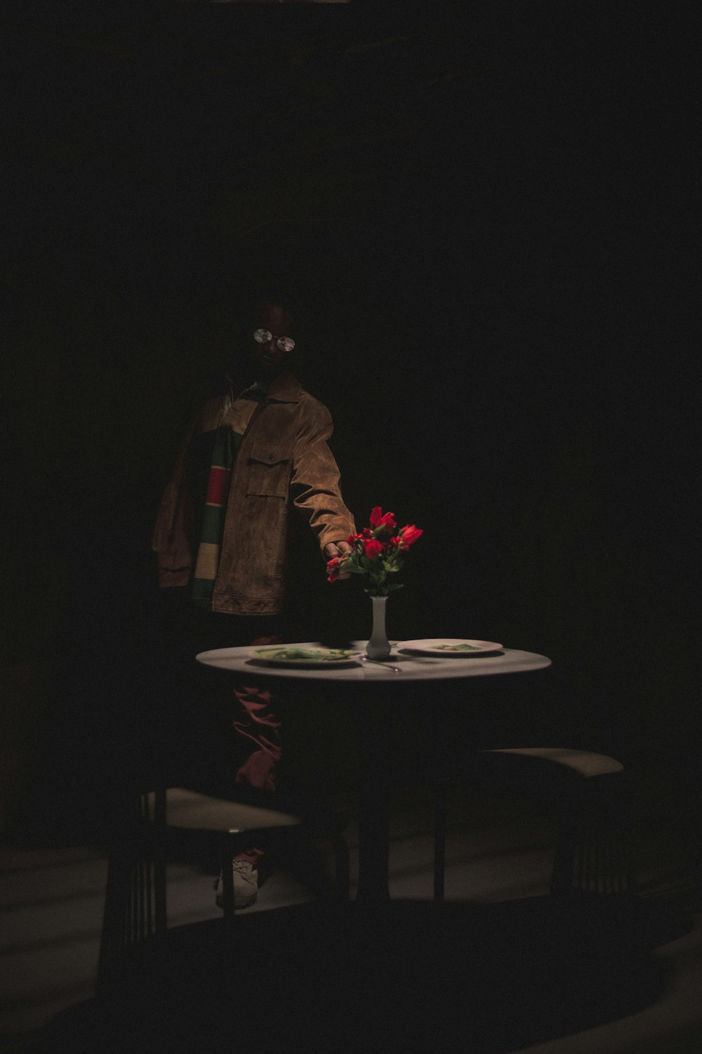 man in brown coat standing near round table