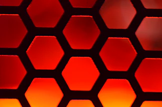 A sleek, hexagonal grid overlay on a deep burgundy background with subtle industrial photography elements.