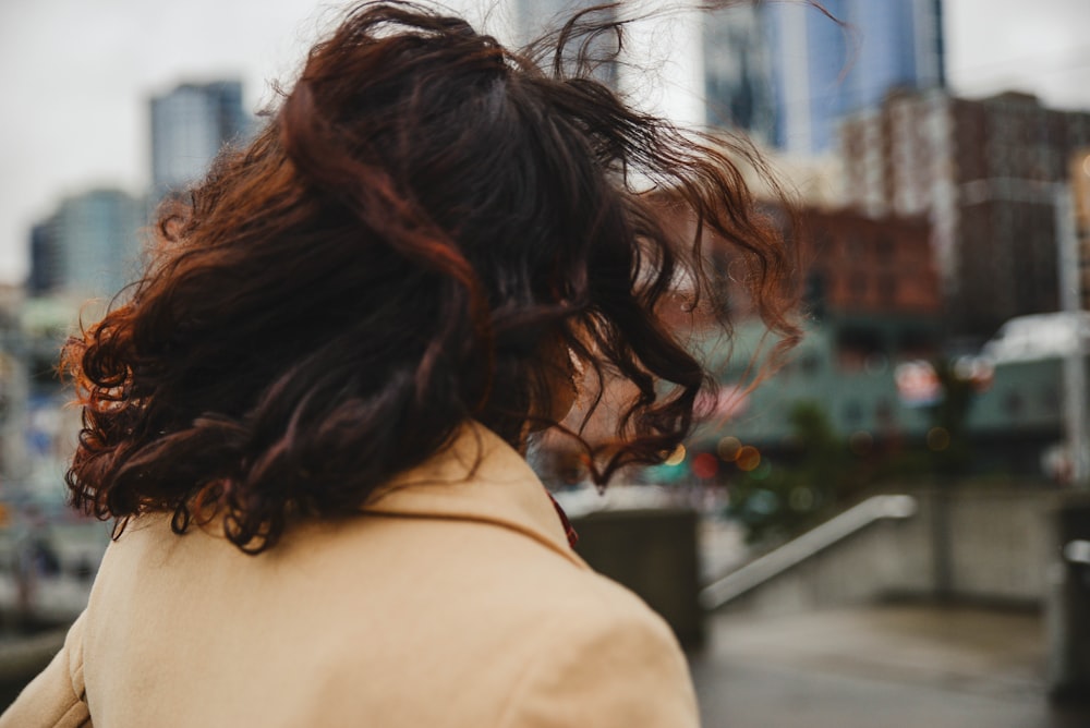 woman in brown shirt standing near building during daytime