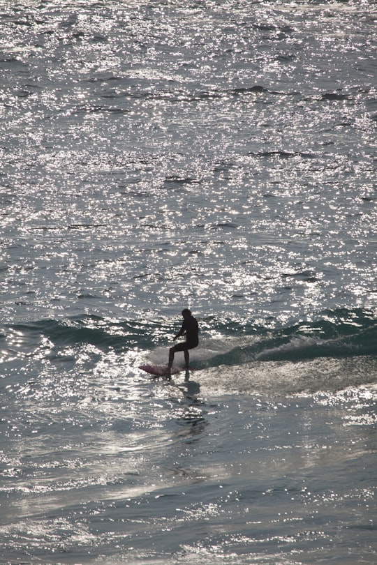 woman in black bikini surfing on sea during daytime in Tamarama Beach Australia