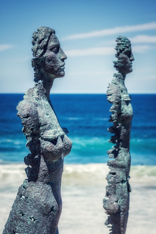 gray concrete statue near body of water during daytime in Tamarama Beach Australia