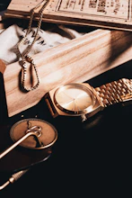 Elegant accessories displayed on a traditional wooden table with desert landscape in the background.