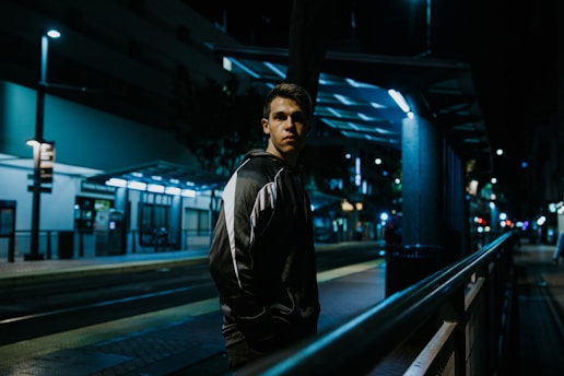 A private detective discreetly observing a city street at dusk, with a blue and white color theme.