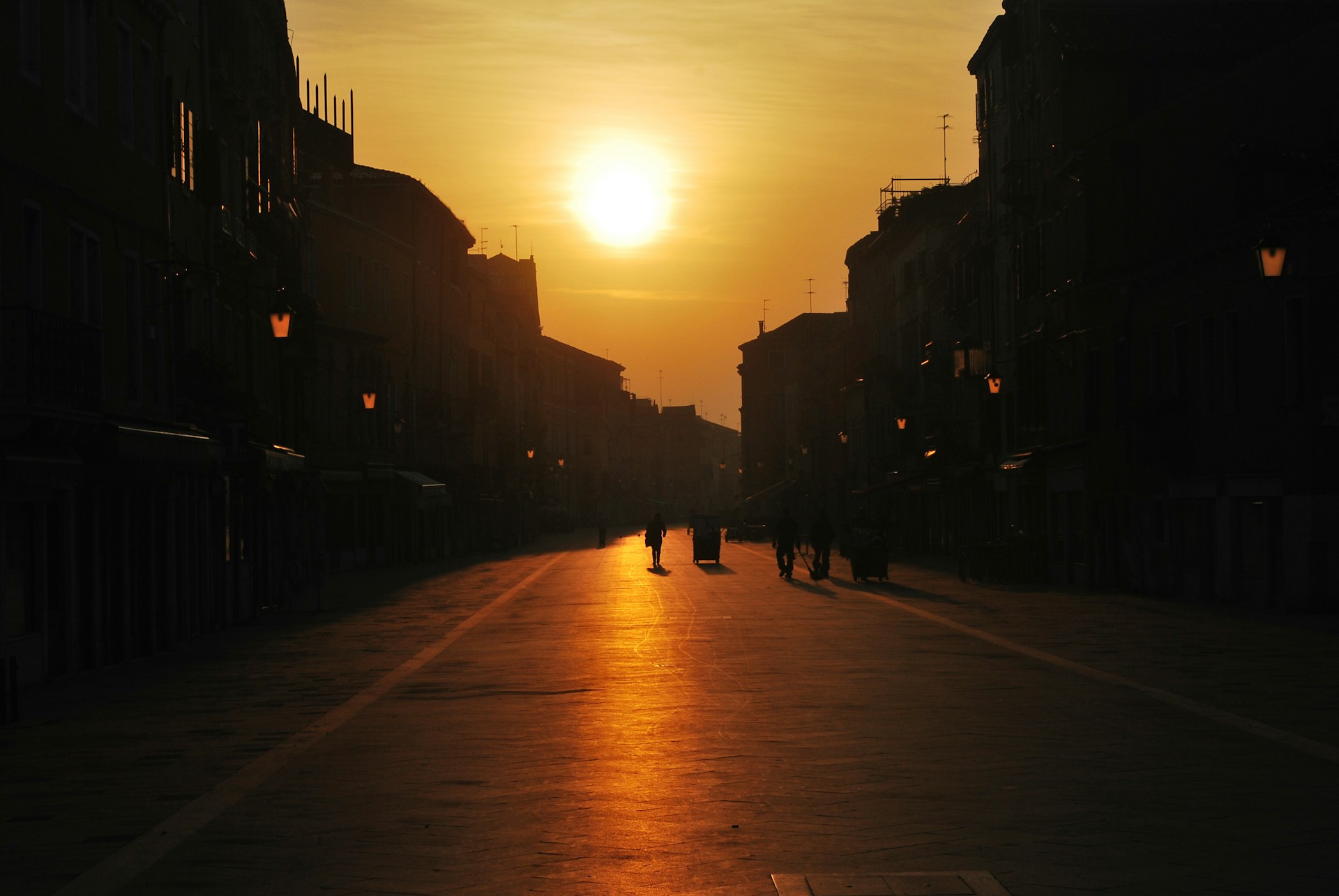 silhouette of people walking on street during sunset