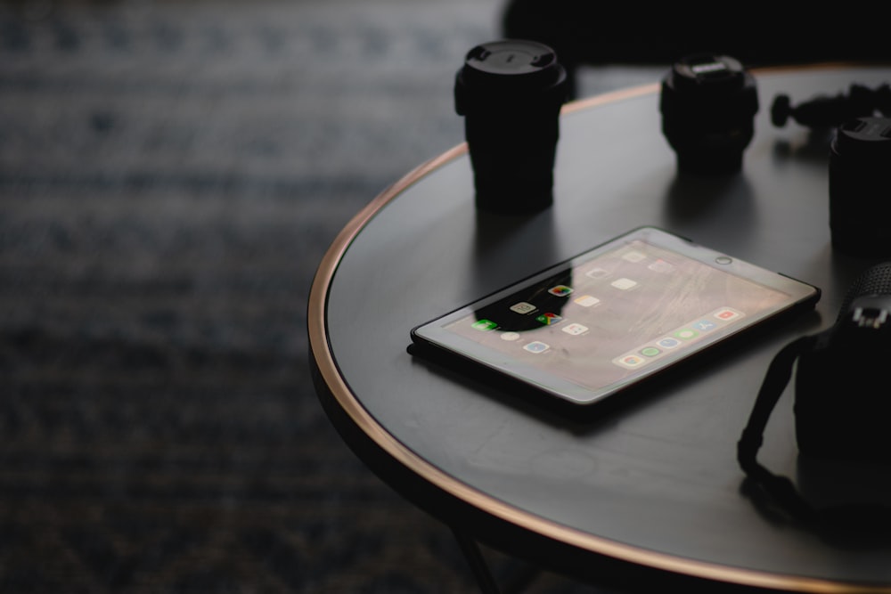 black smartphone on brown wooden round table