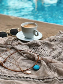 A serene lifestyle shot of a woman wearing subtle, modern jewelry while enjoying a quiet morning coffee.