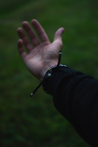 person wearing black watch showing left hand