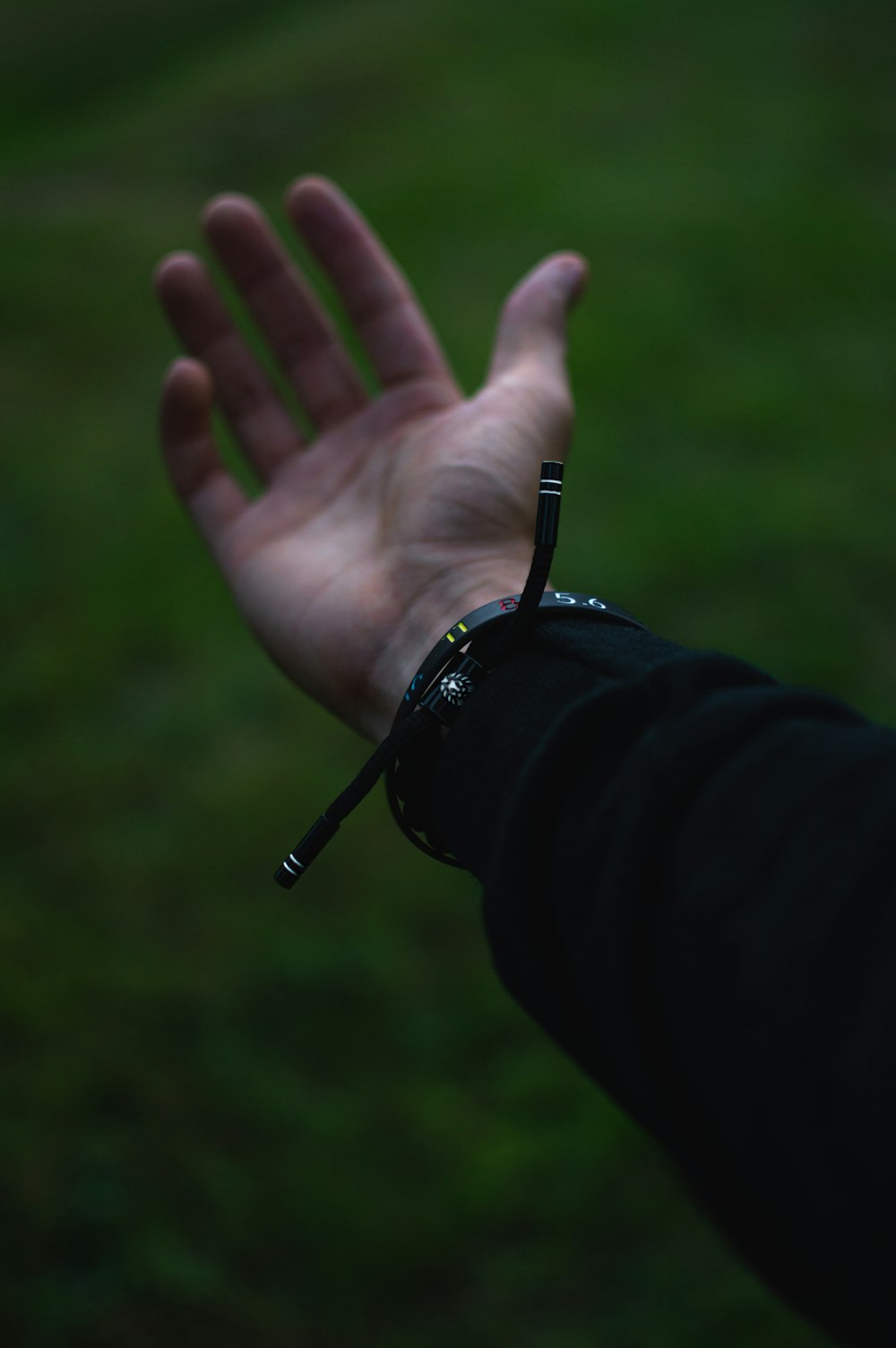 person wearing black watch showing left hand