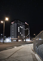 Night view of the hotel illuminated softly against the starry sky.