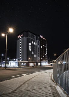 Night view of the hotel illuminated softly against the starry sky.