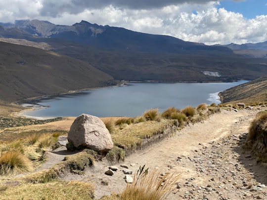 brown rock formation near body of water during daytime in Parque Nacional Natural Los Nevados Colombia