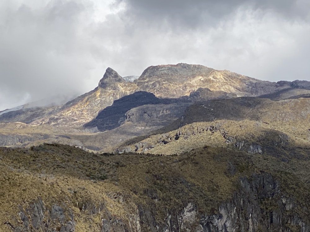 brown and green mountain under cloudy sky during daytime