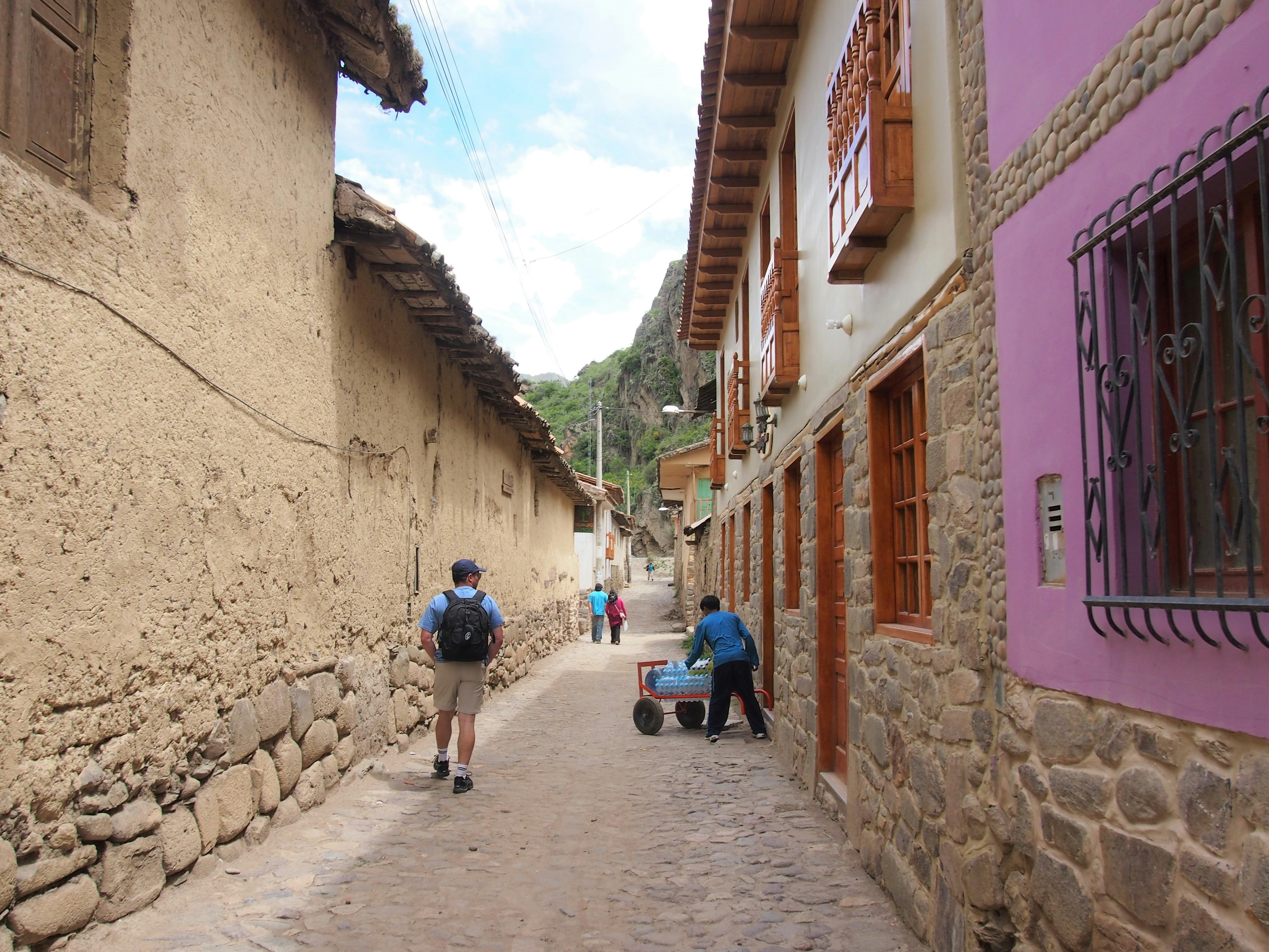 people walking on pathway between concrete houses during daytime