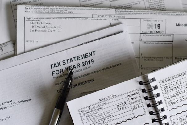 A collection of tax documents from 2019 and a mileage log with a pen