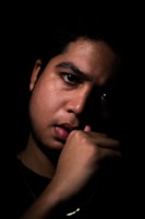 A professional corporate portrait with dramatic lighting on a dark background.