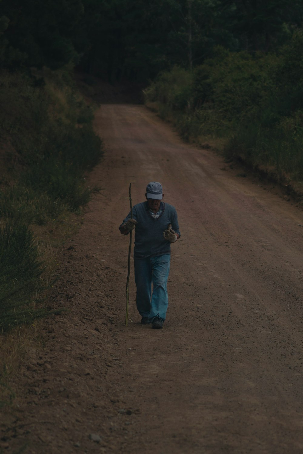 man in black jacket walking on dirt road during daytime